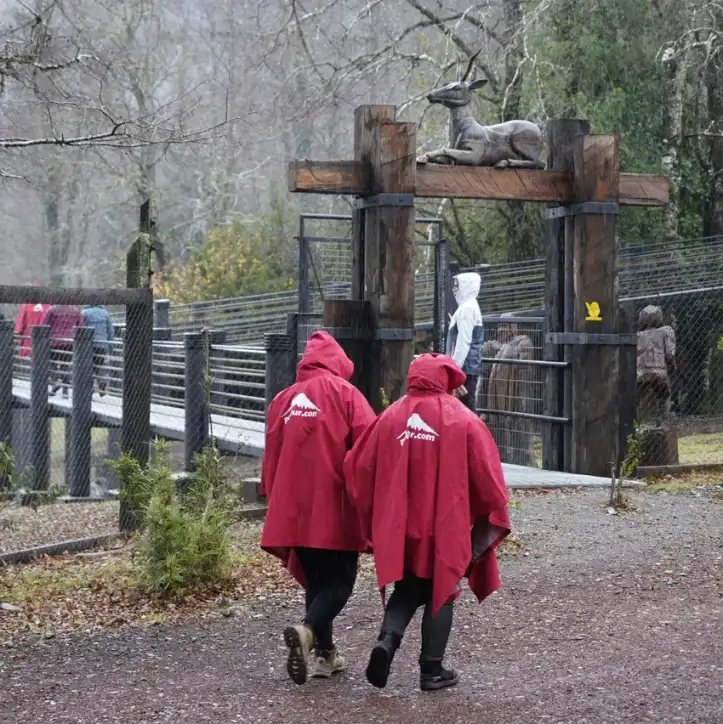 Pasajeros del tour Politur con capas de lluvia en el portal del criadero de ciervos de Huilo Huilo